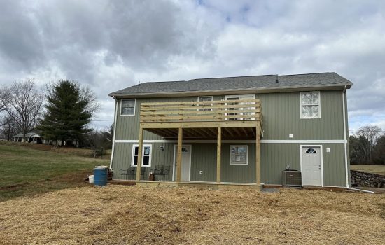 Elevated deck under construction with pressure treated framing and guardrail posts
